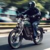 Zu sehen ist eine Royal Enfield Flying Flea C6 mit männlichem Motorradfahrer während der Fahrt.