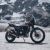 Zu sehen ist eine Royal Enfield Himalayan 440 im Seitenprofil auf einer Gebirgsebene. Im Hintergrund Gebirge des Himalaya.